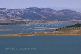 Image du Maroc Professionnelle de  Le barrage Oued El Makhazine, conçu pour le développement et  l'irrigation du périmètre du Loukkos. Ainsi les champs situés dans le triangle Ksar El Kébir, Larache, Moulay Bouselham profitent de cette infrastructure. Cette importante réalisation située sur El Oued Loukkos sert à la régularisation inter annuelle des débits tout en formant une protection contre les crues, au Jeudi 1er Septembre 2005 à cette datte le barrage dispose 309 Million de M3. (Photo / Abdeljalil Bounhar) 